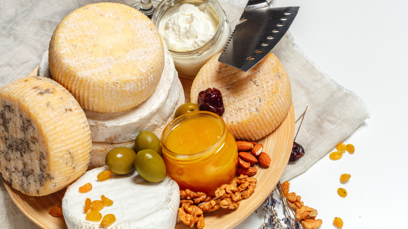 Сыр с плесенью на тарелке оливками, орехами и медом 