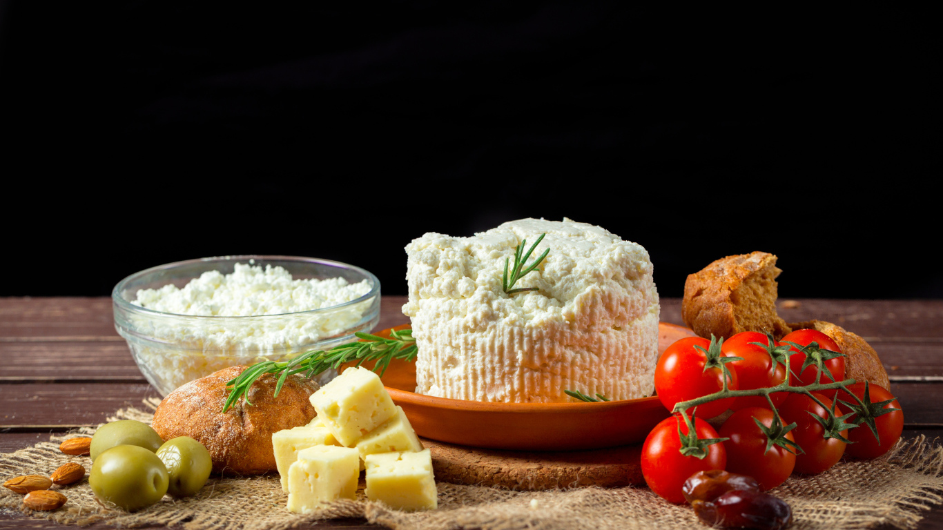 Творог на столе с сыром, хлебом и помидорами