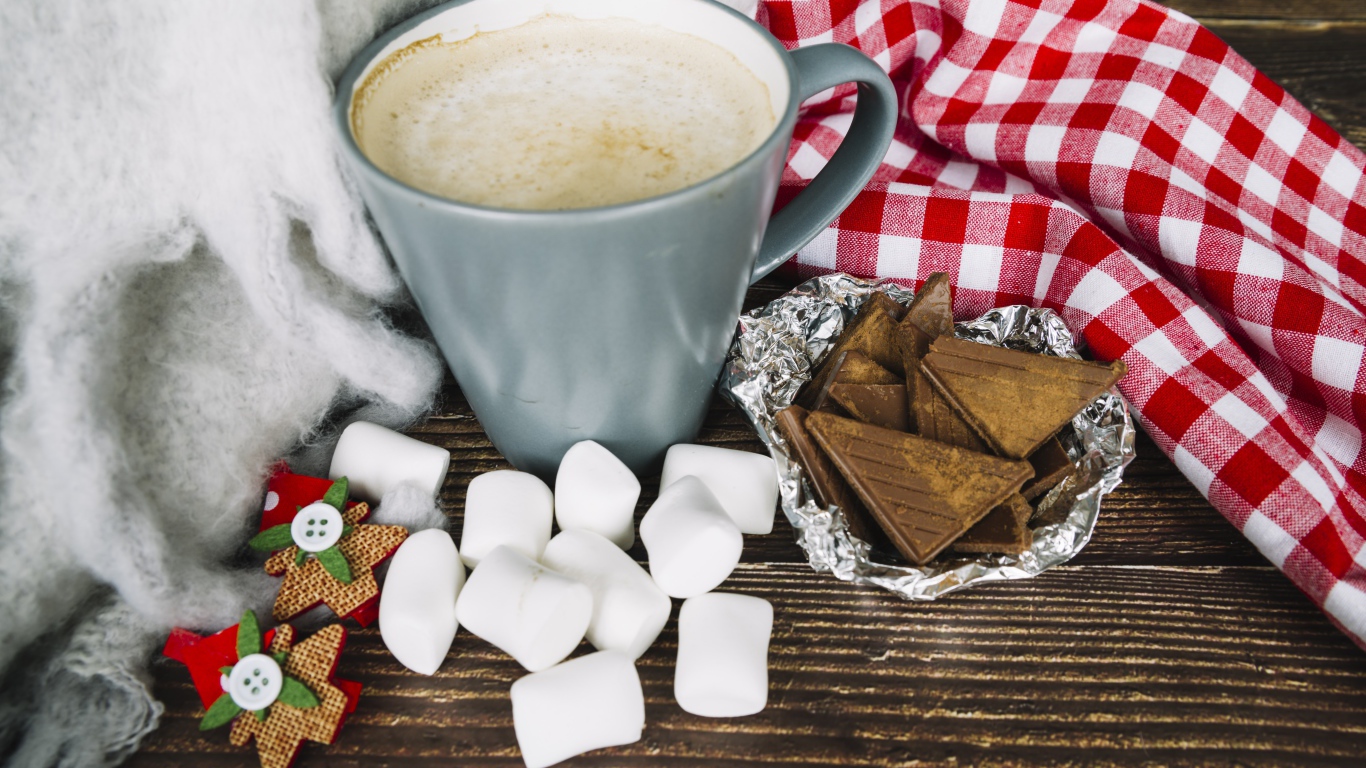 Чашка кофе на столе с маршмеллоу и шоколадом