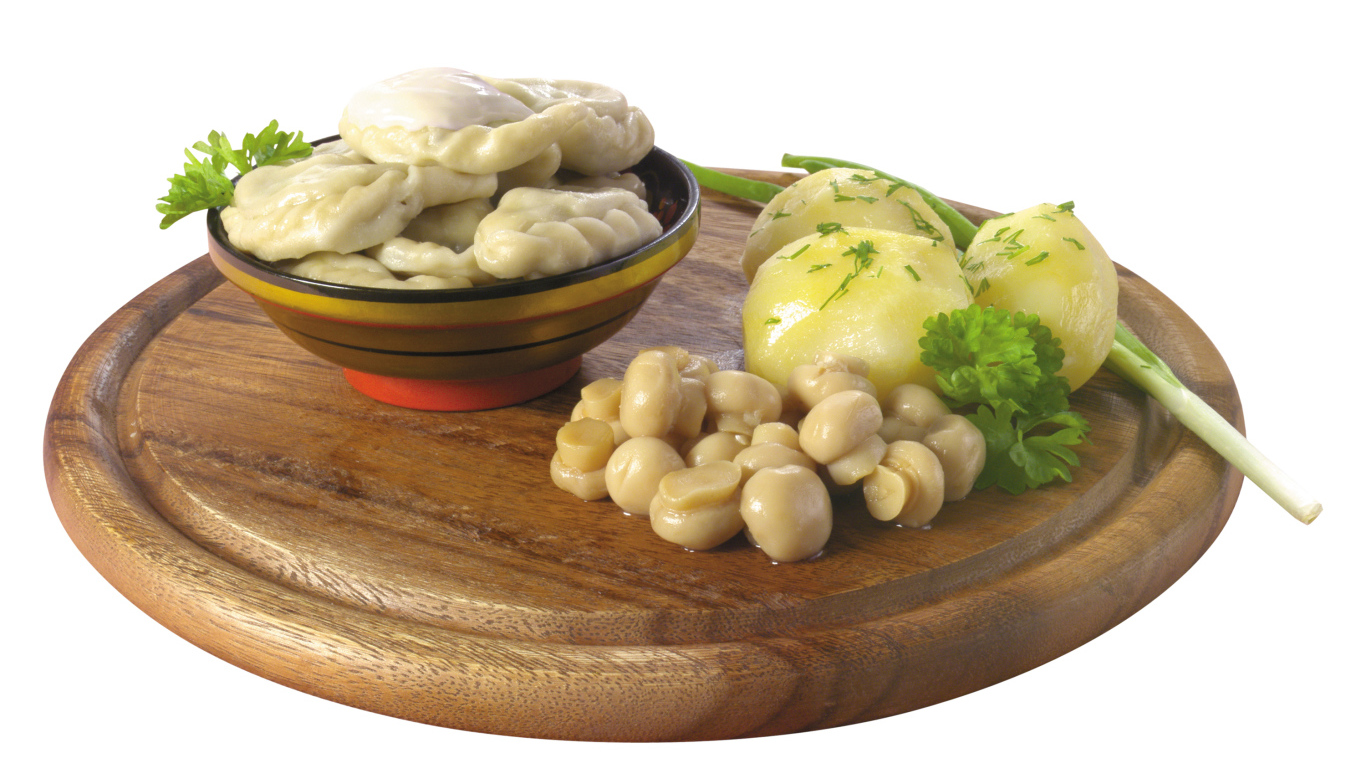 Вареники с грибами и вареной картошкой на деревянной доске на белом фоне