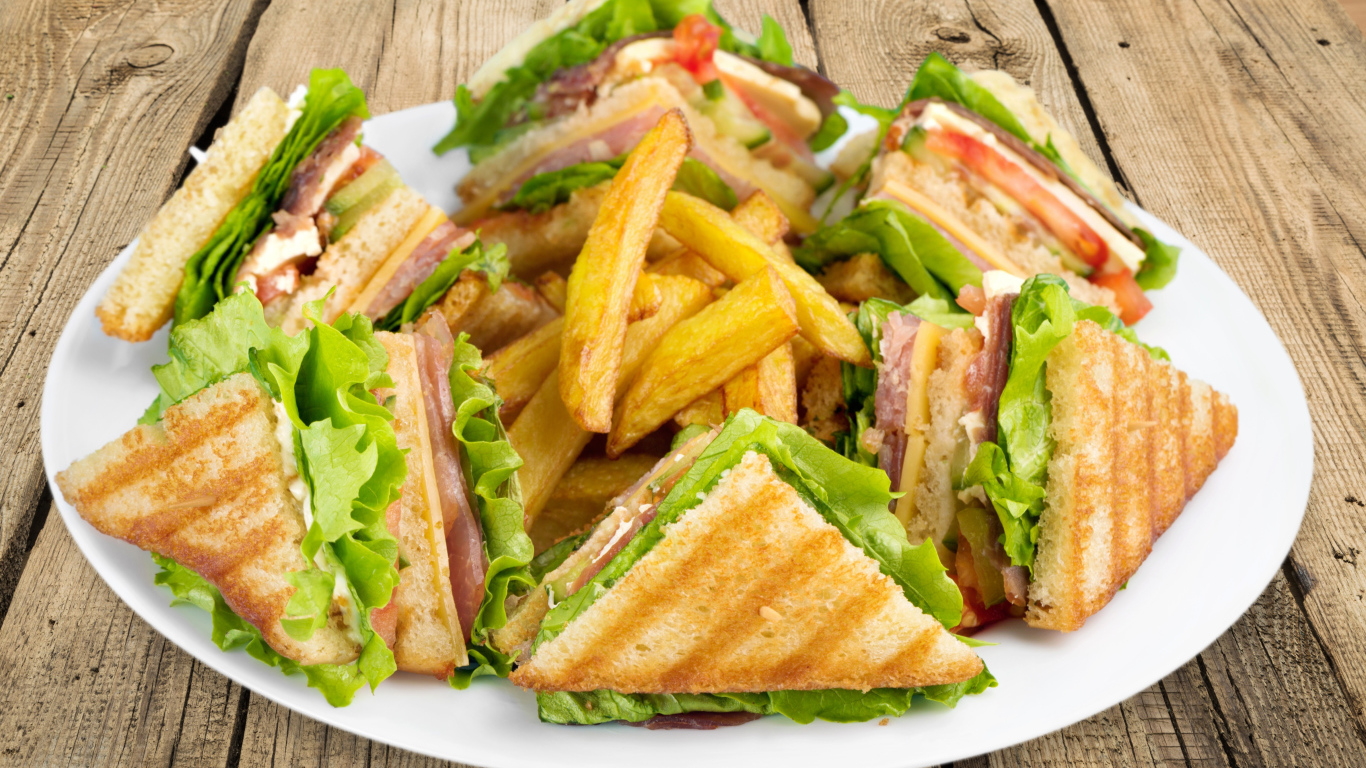 Сэндвичи с ветчиной на тарелке с картофелем фри 