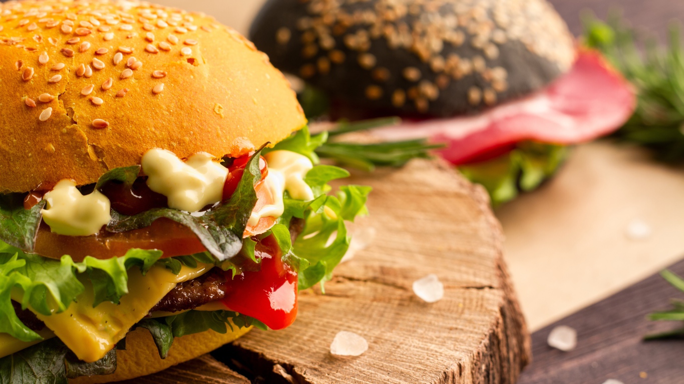 Гамбургер на деревянной доске крупным планом