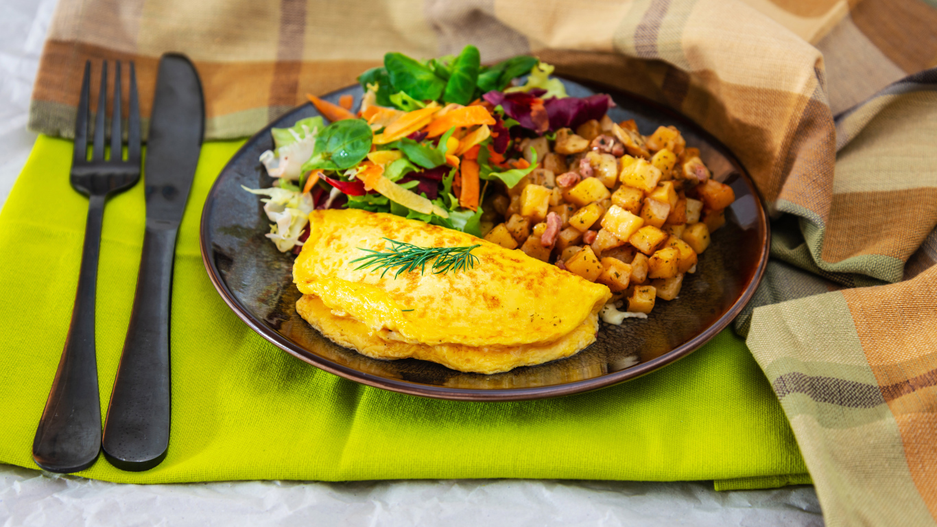 Омлет на тарелке с салатом и овощами