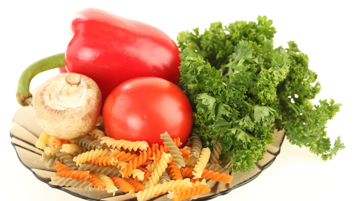 Тарелка с макаронами, красным перцем, помидором, шампиньоном и зеленью петрушки