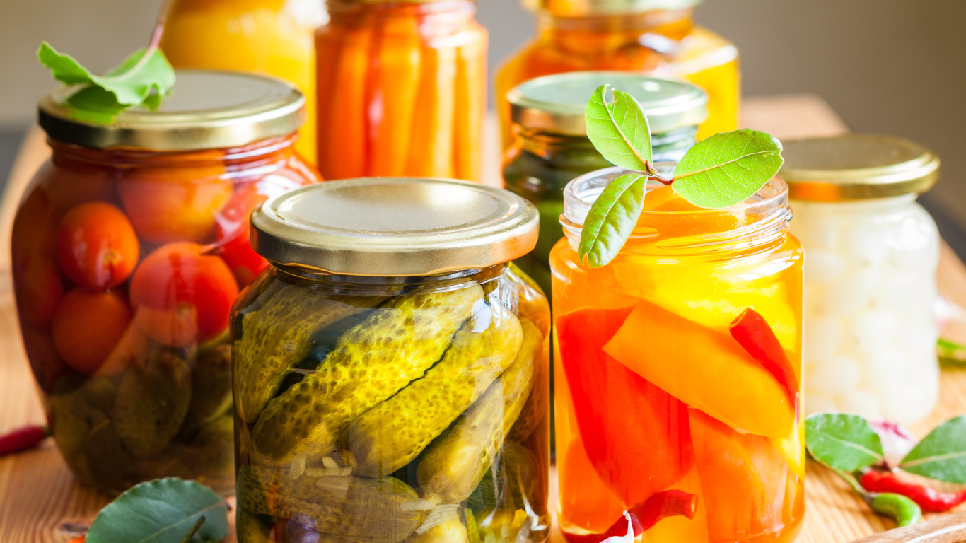 Консервация в стеклянных банках на столе со специями