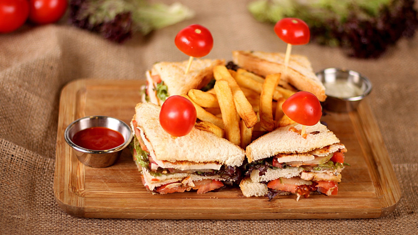 Сэндвичи на доске с картофелем фри и соусом