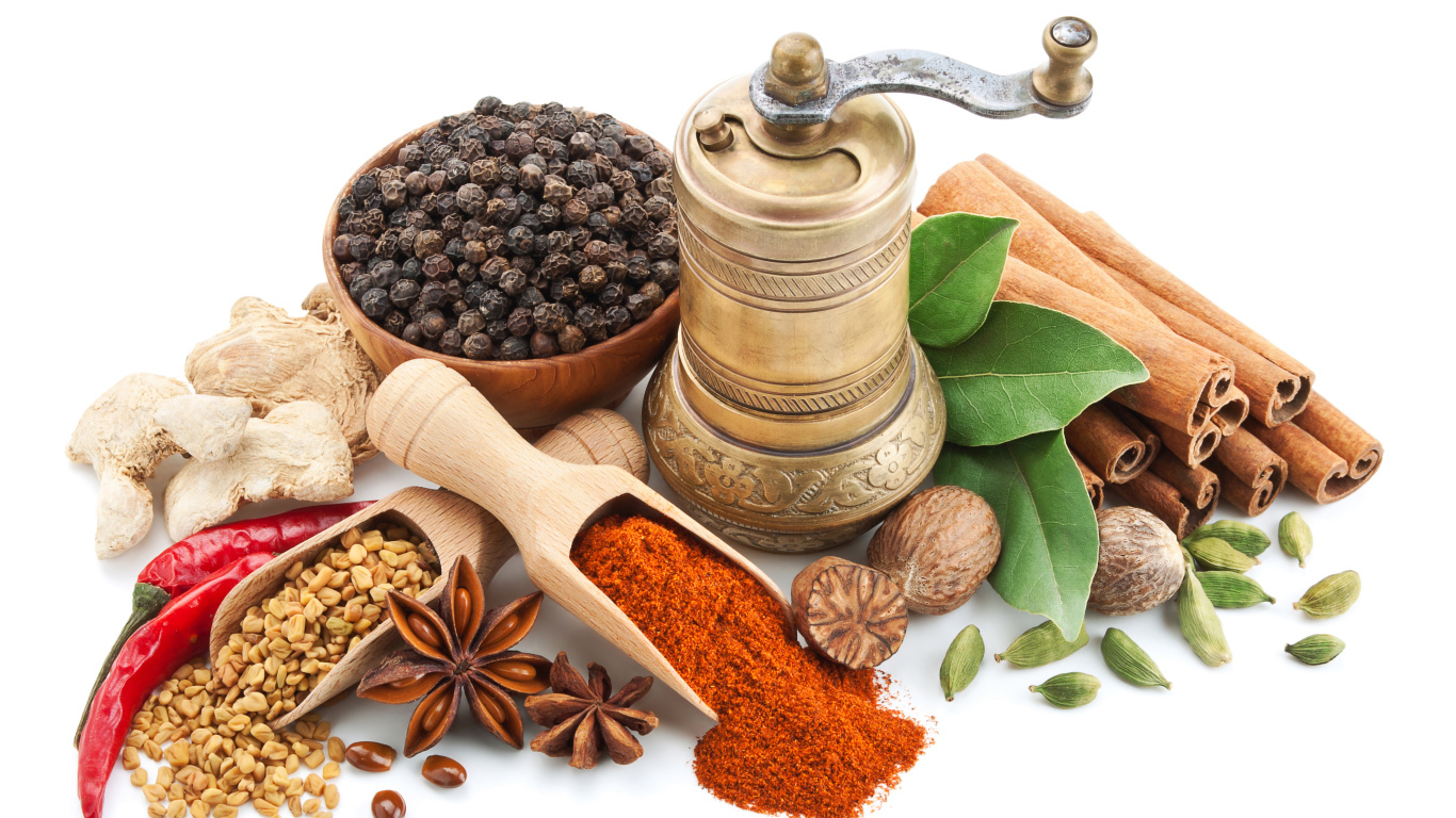 Пряные специи на столе с мельницей на белом фоне