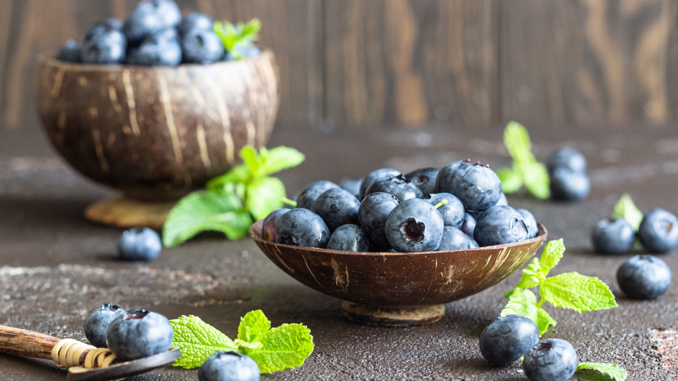 Ягоды черники стоят на столе в посуде