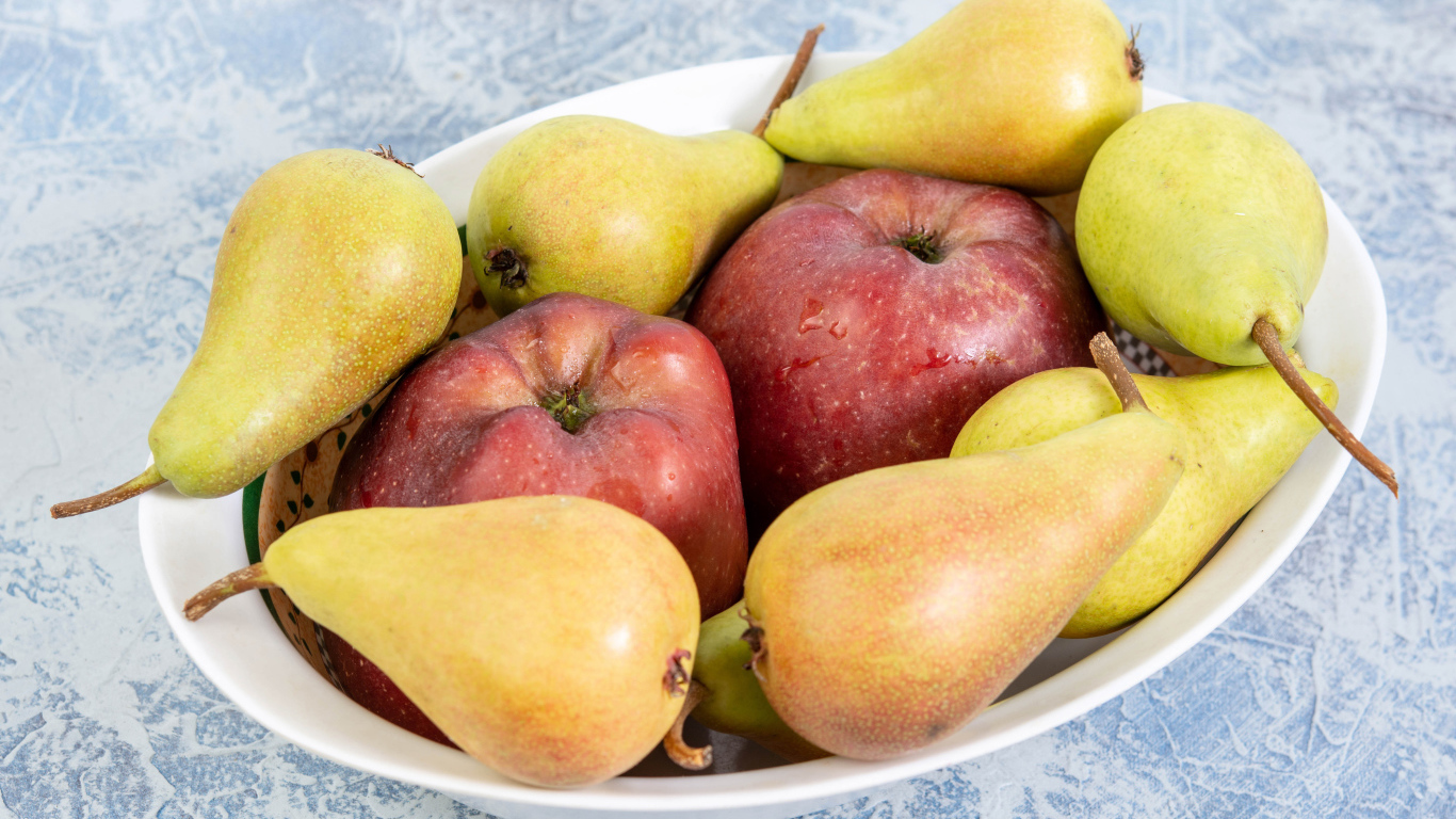 Красные яблок и груши на тарелке на столе