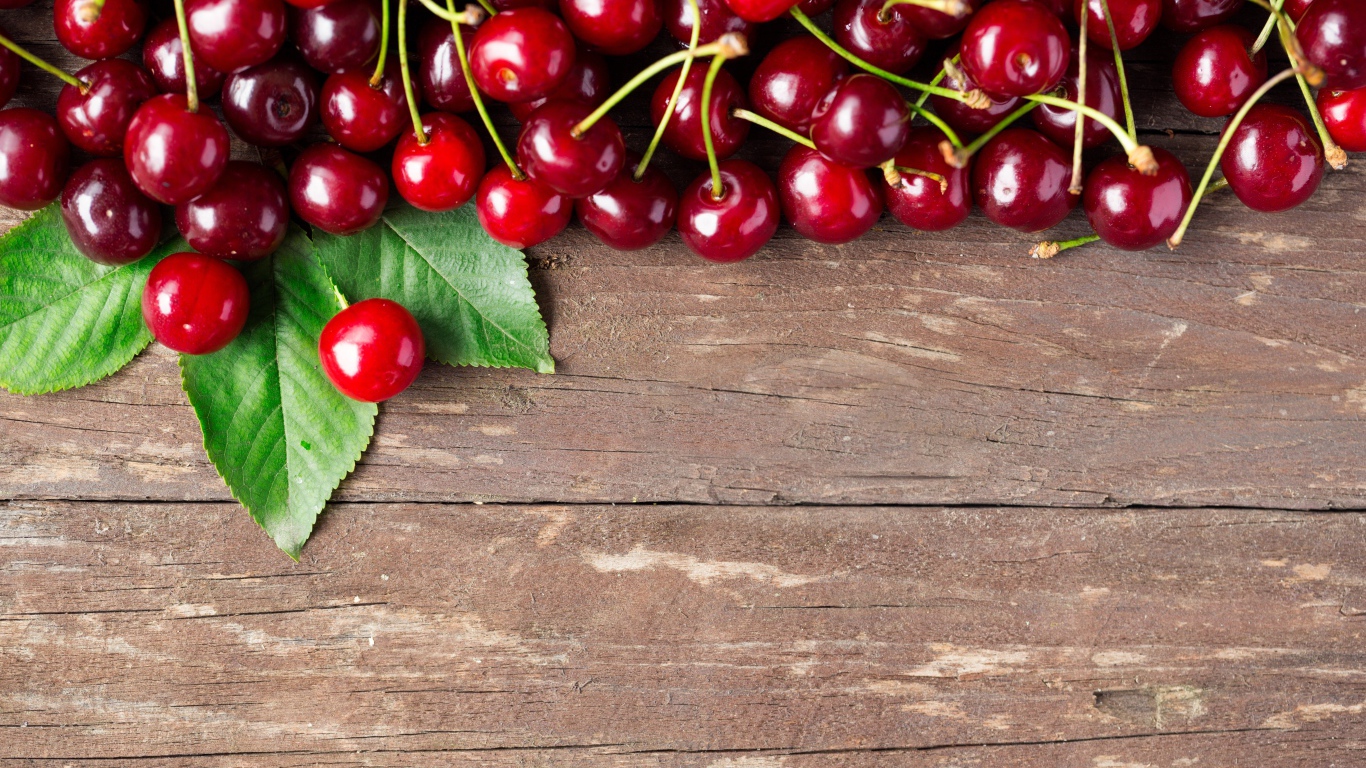 Красные спелые вишни на деревянном столе