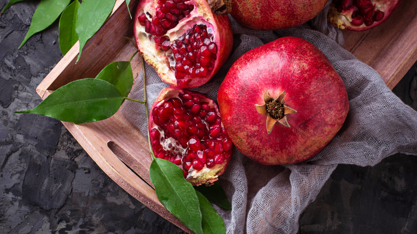 Спелые красные гранаты в деревянном ящике