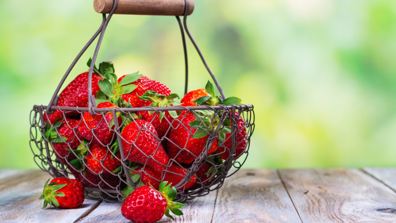 Спелая красная клубника в корзине на столе