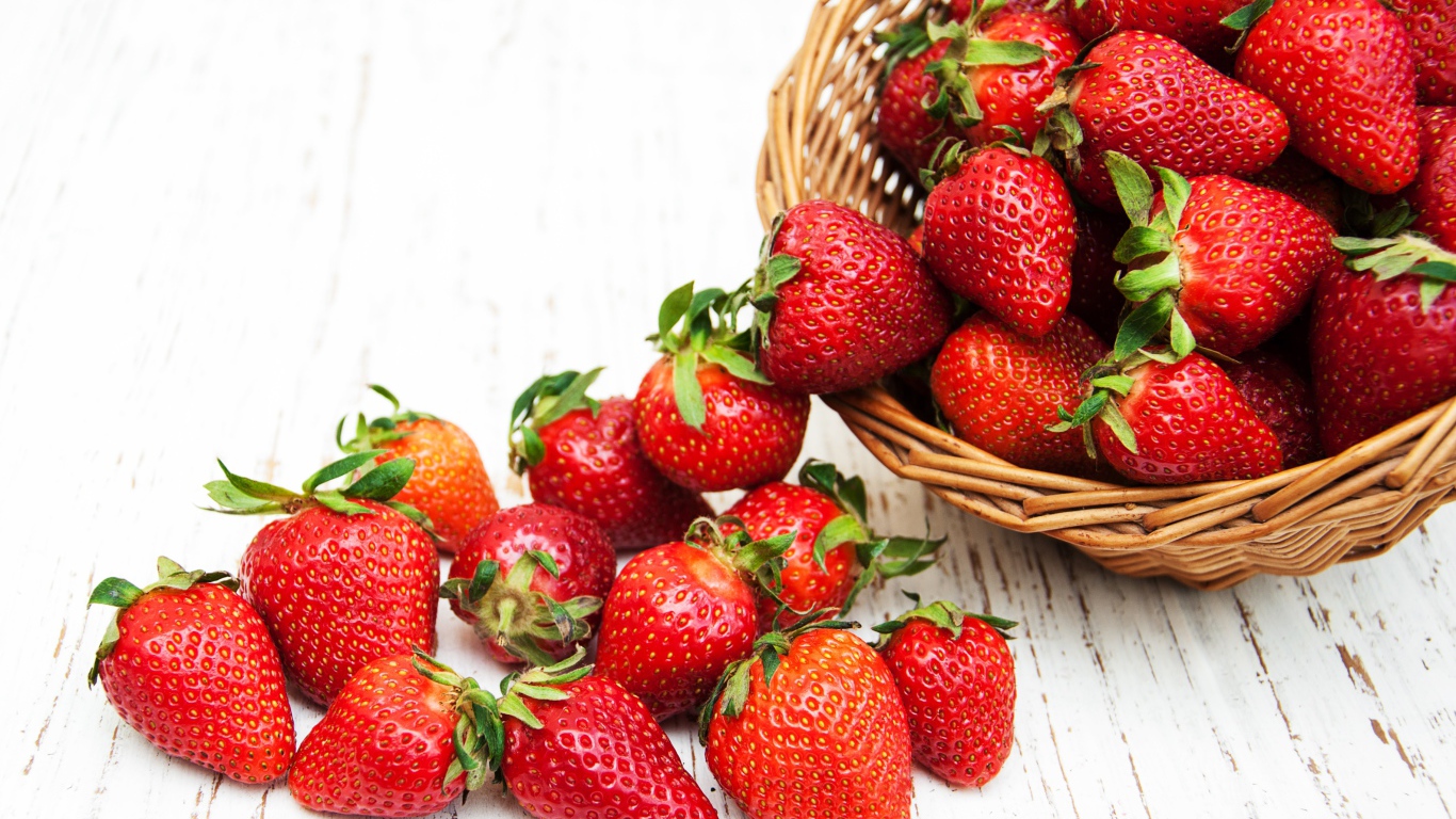 Клубника в корзине на деревянном столе