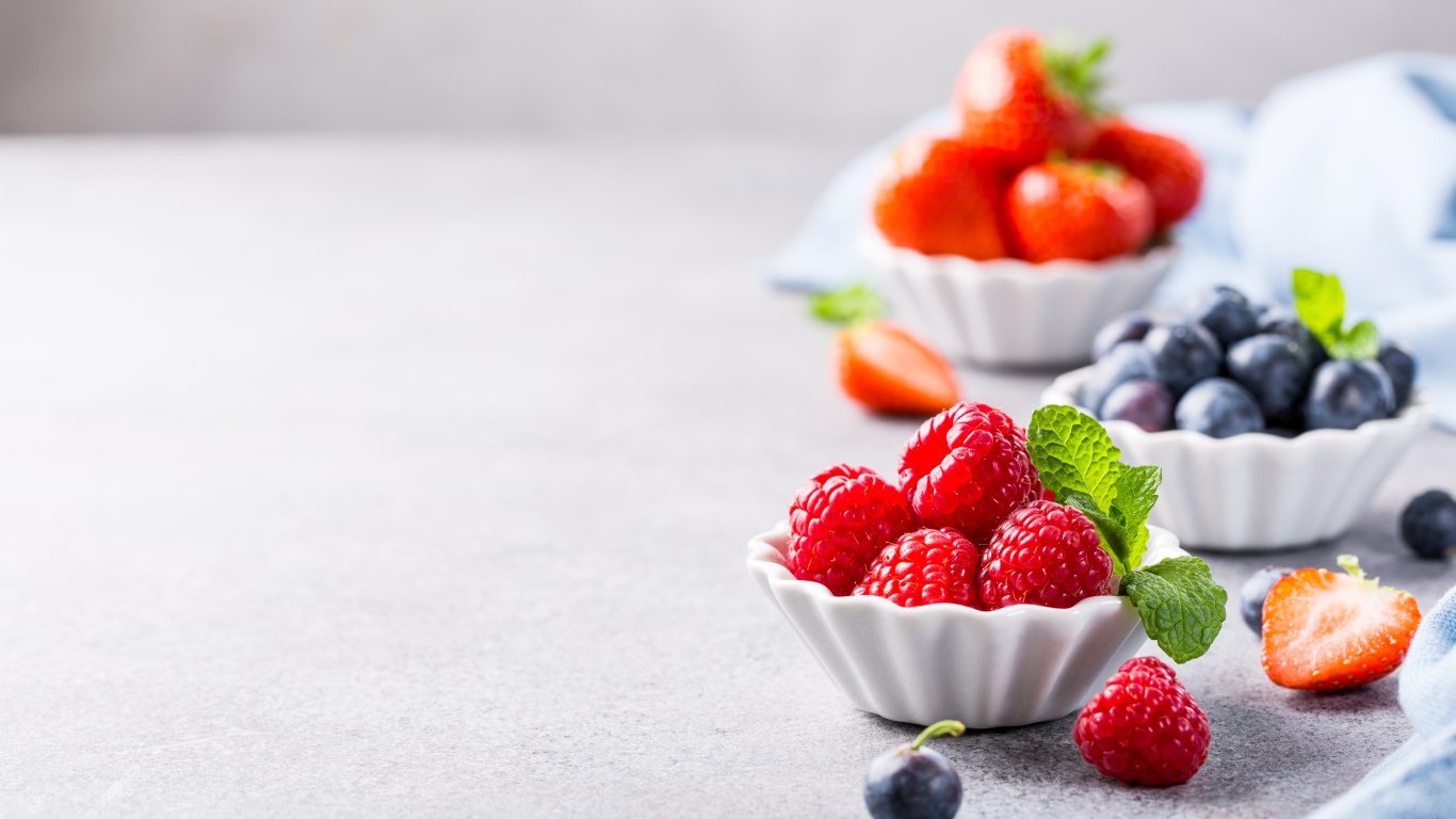 Ягоды клубники, малины и черники на столе 