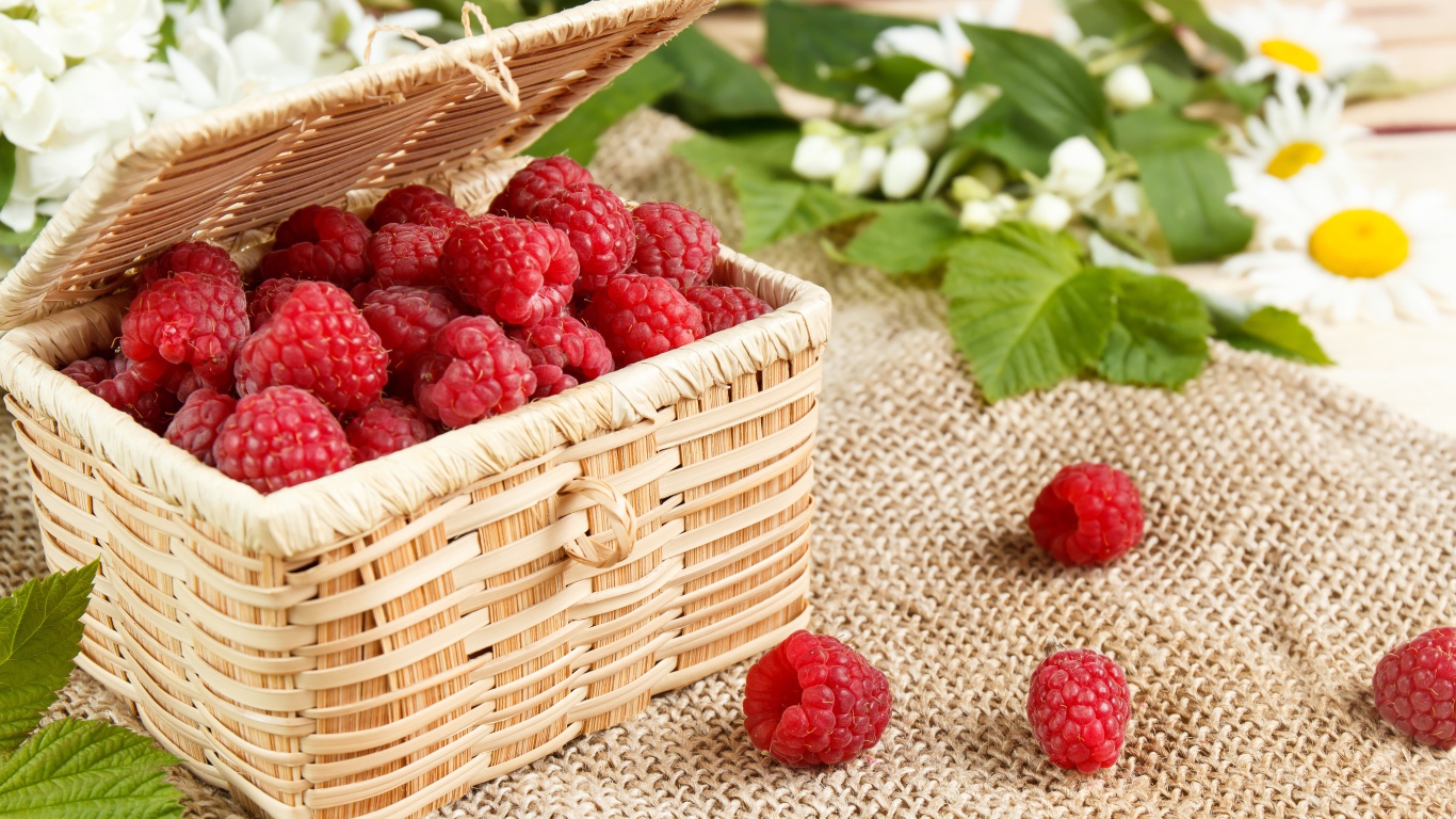 Плетеная корзина на столе с ягодами малины 