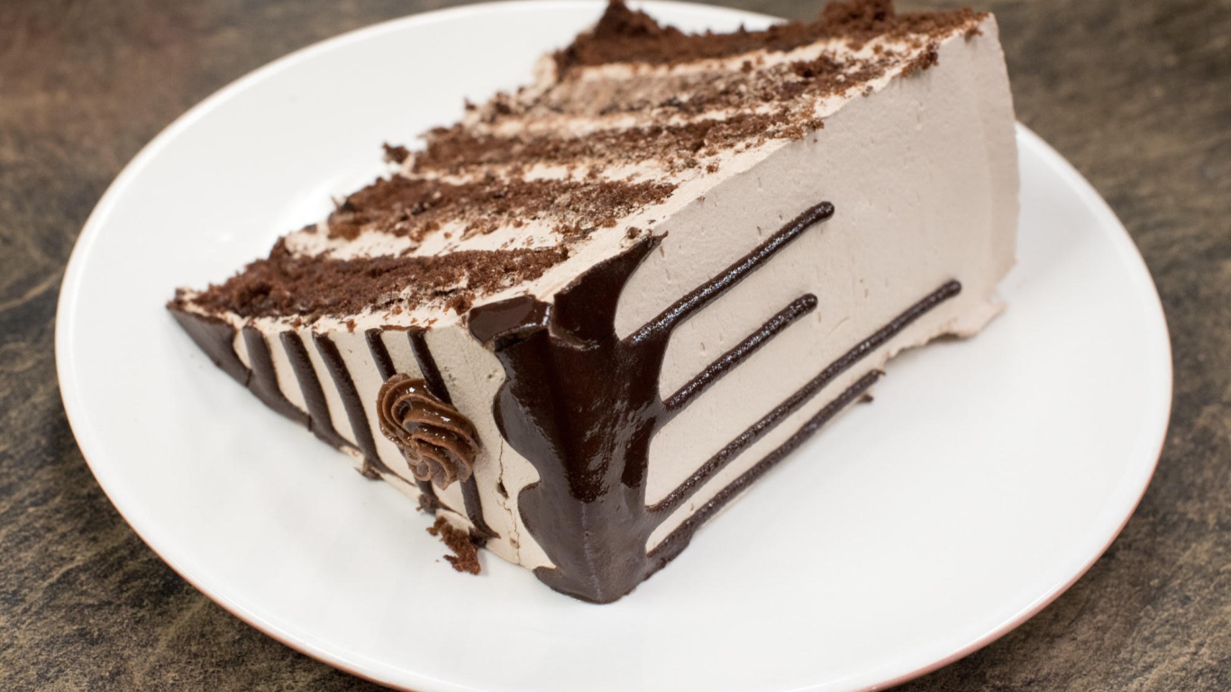 Кусок торта с кремом на белой тарелке