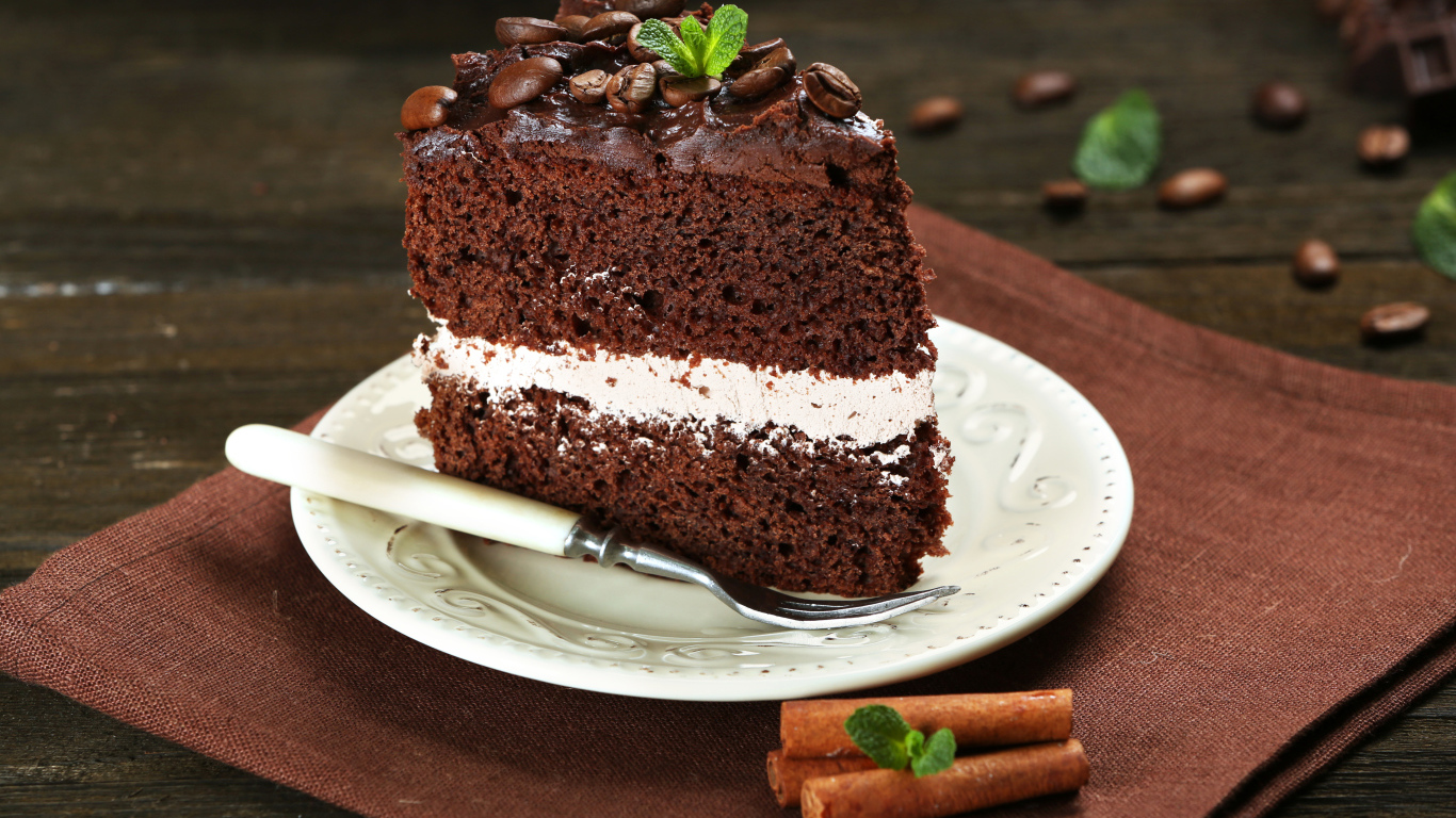 Кусок шоколадного торта с кремом и зернами кофе