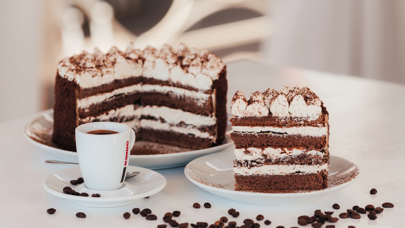 Аппетитный торт с чашкой кофе на столе