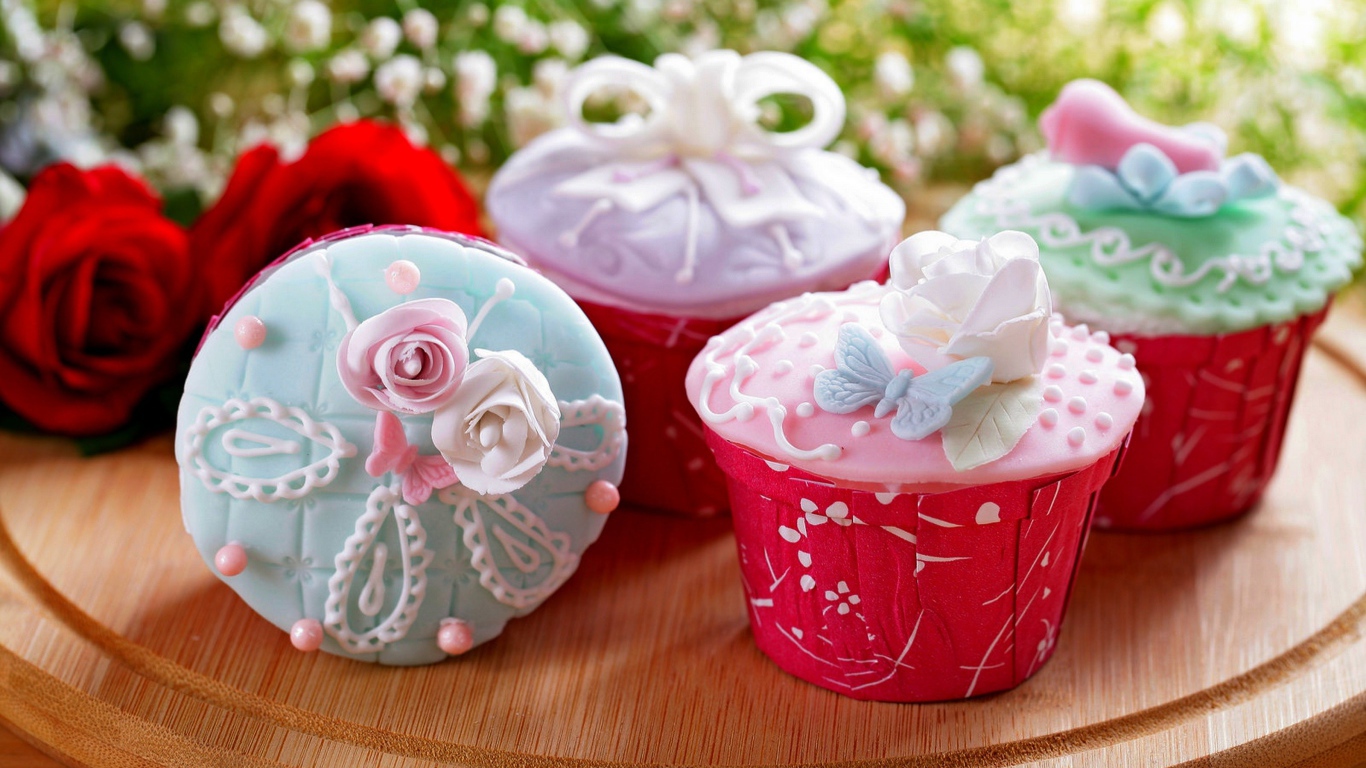 Красиво украшенные кексы на доске с цветами