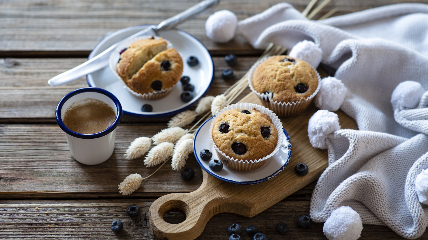 Кексы с черникой на столе с колосьями и кофе