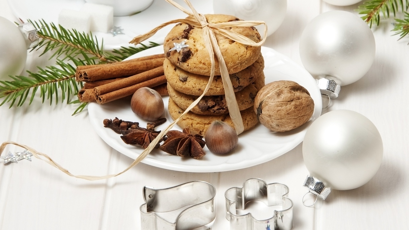 Печенье на тарелке с орехами и корицей на столе с игрушками 