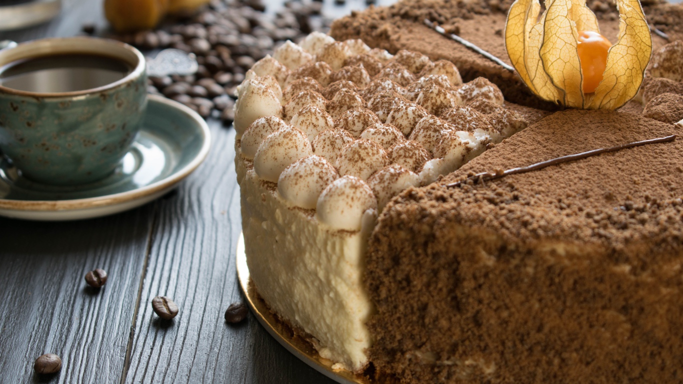 Вкусный торт с кремом и физалисом на столе с кофе