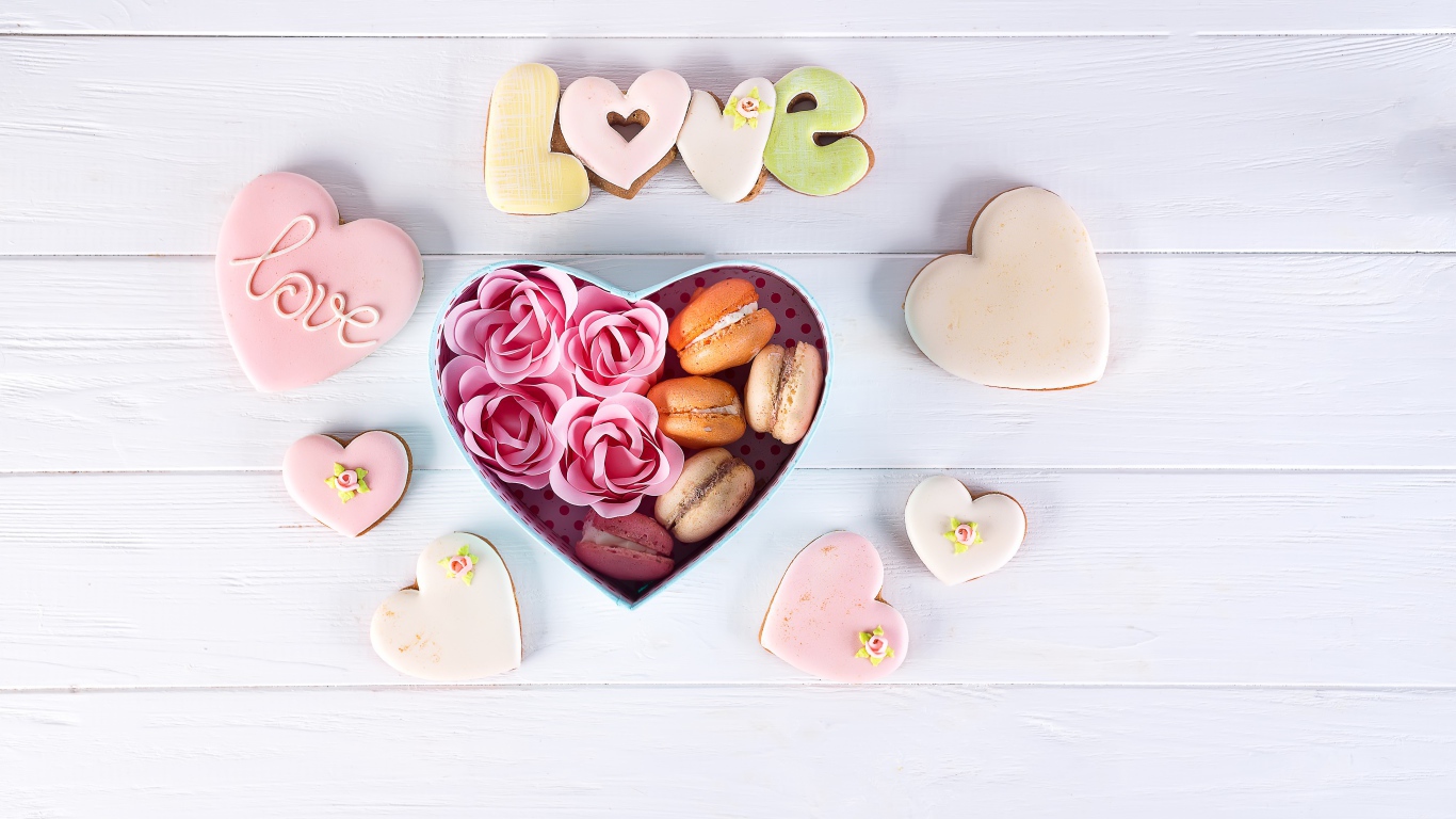 Печенье в форме сердца на столе с коробкой с десертом макарун