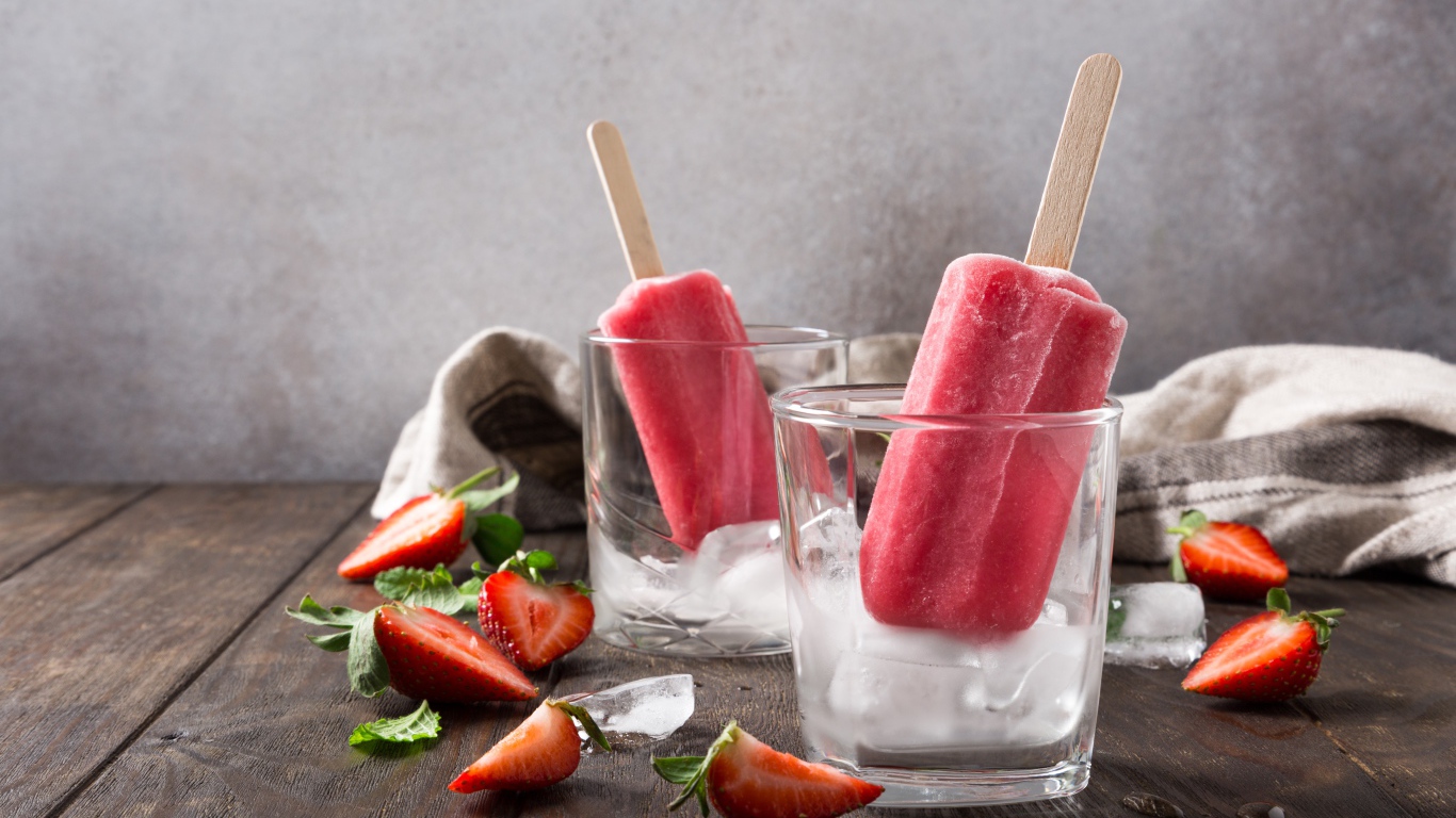 Фруктовое мороженое в стакане со льдом на столе с клубникой