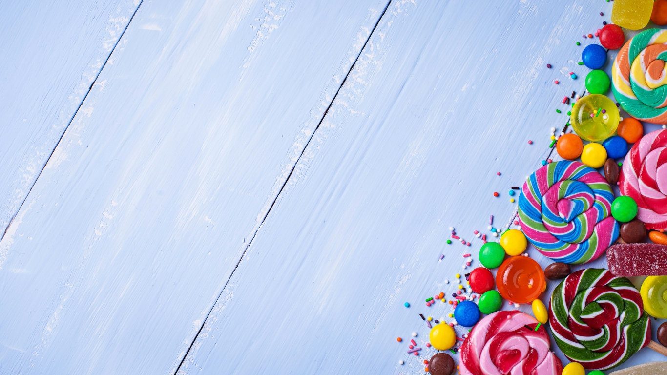 Разноцветные конфеты на голубом столе