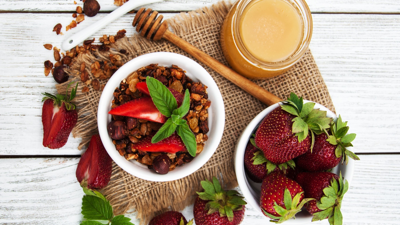 Орехи с ягодами клубники и медом на столе