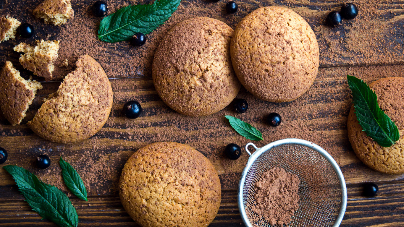 Овсяное печенье с черной смородиной, листьями мяты и какао на столе