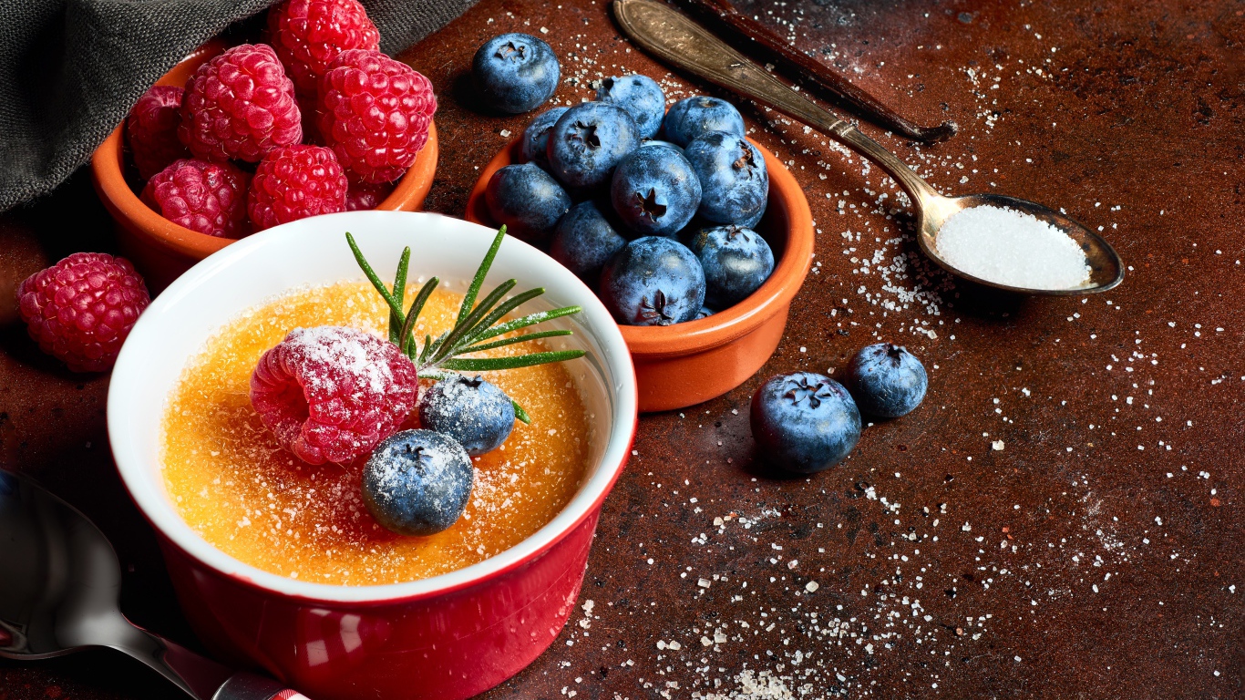 Пудинг на столе с ягодами малины и черники