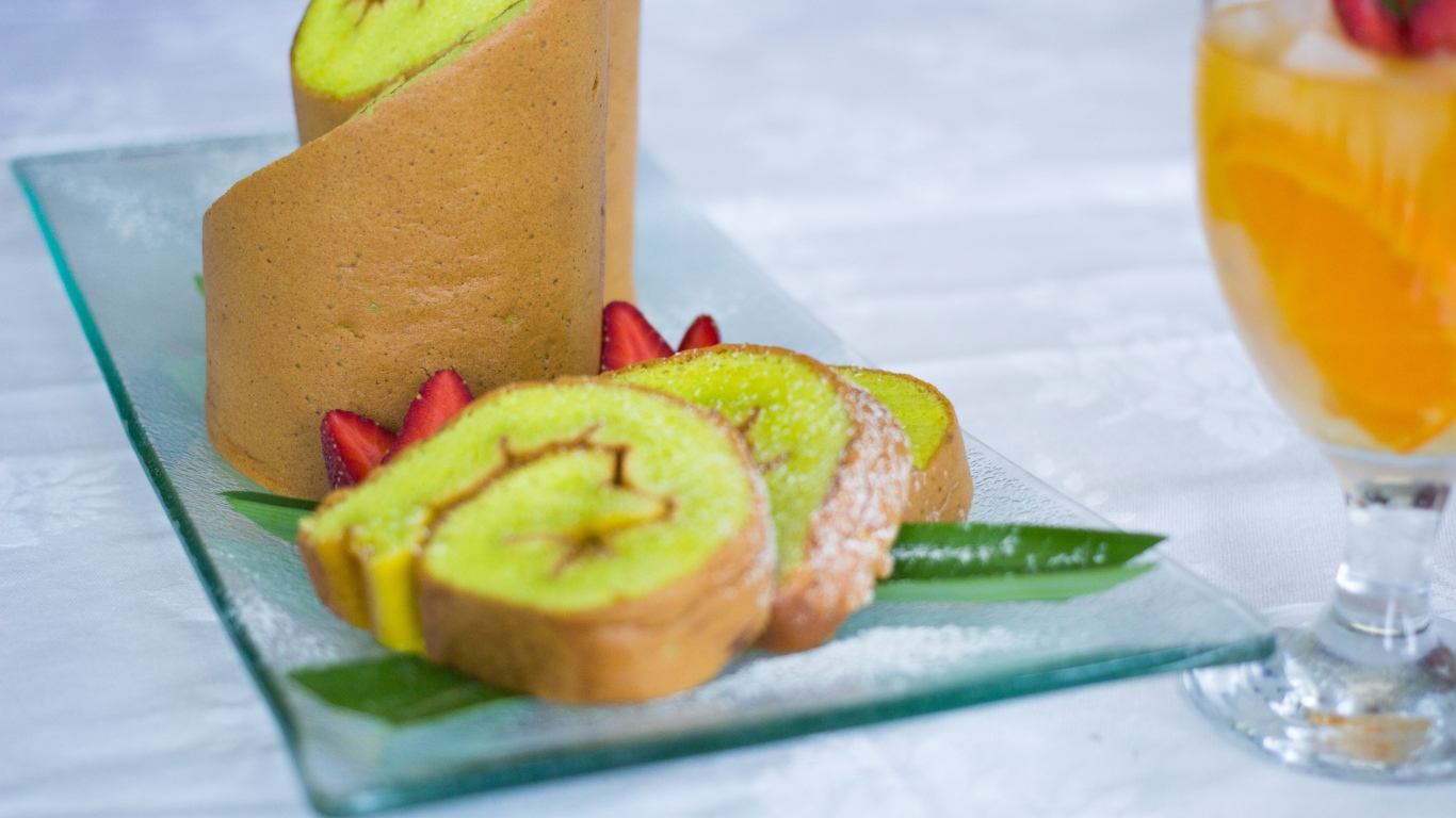 Рулет с сахарной пудрой и клубникой на столе