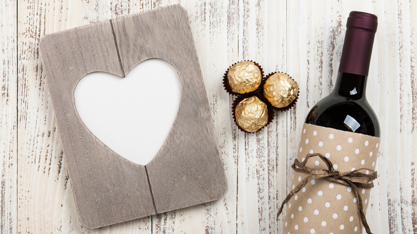 Бутылка вина на столе с конфетами и сердцем 