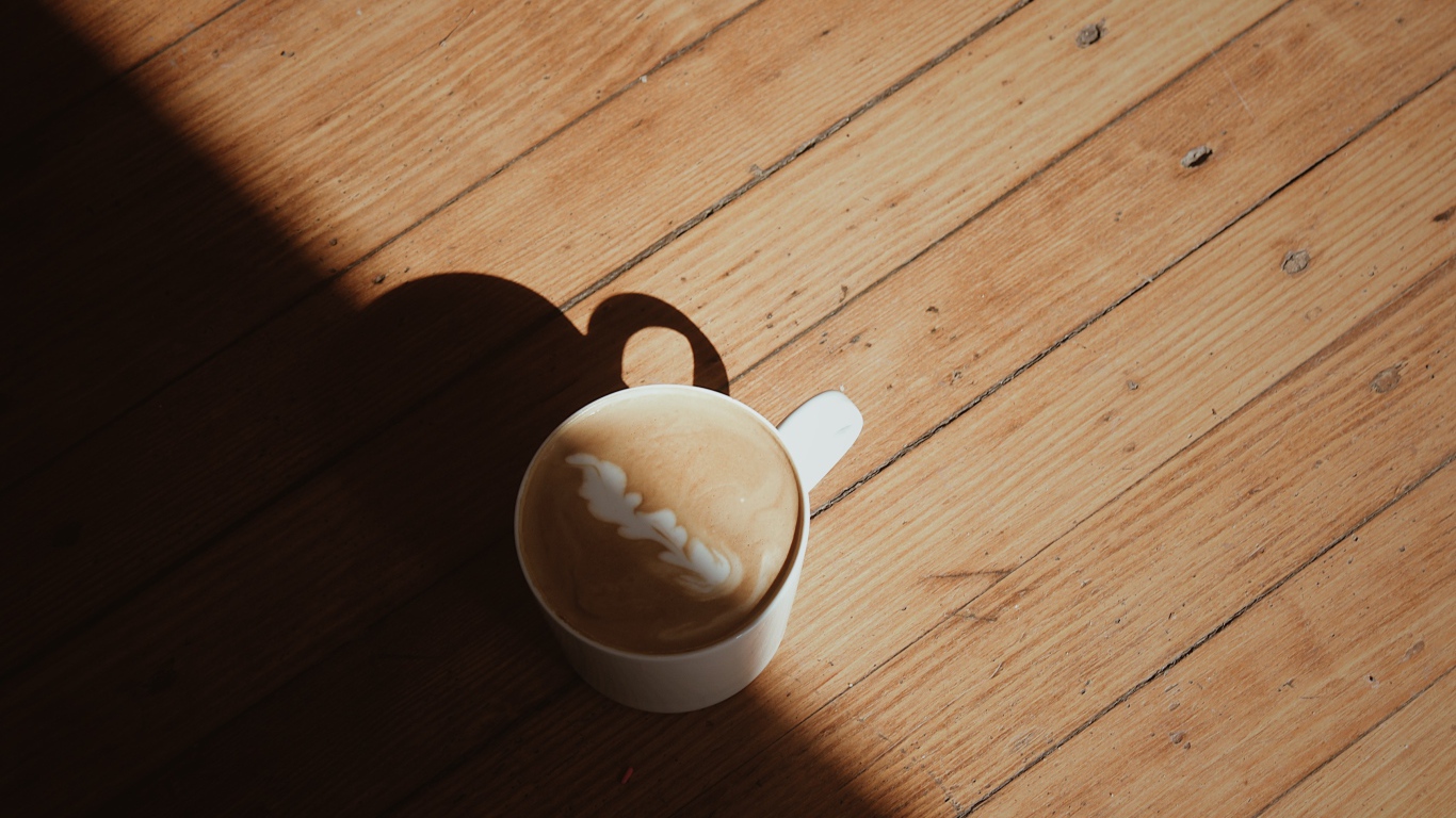 Чашка капучино с рисунком на деревянном столе