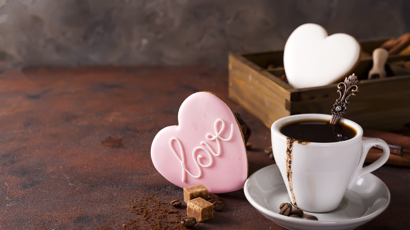 Чашка кофе на столе с сахаром и печеньем в форме сердца 