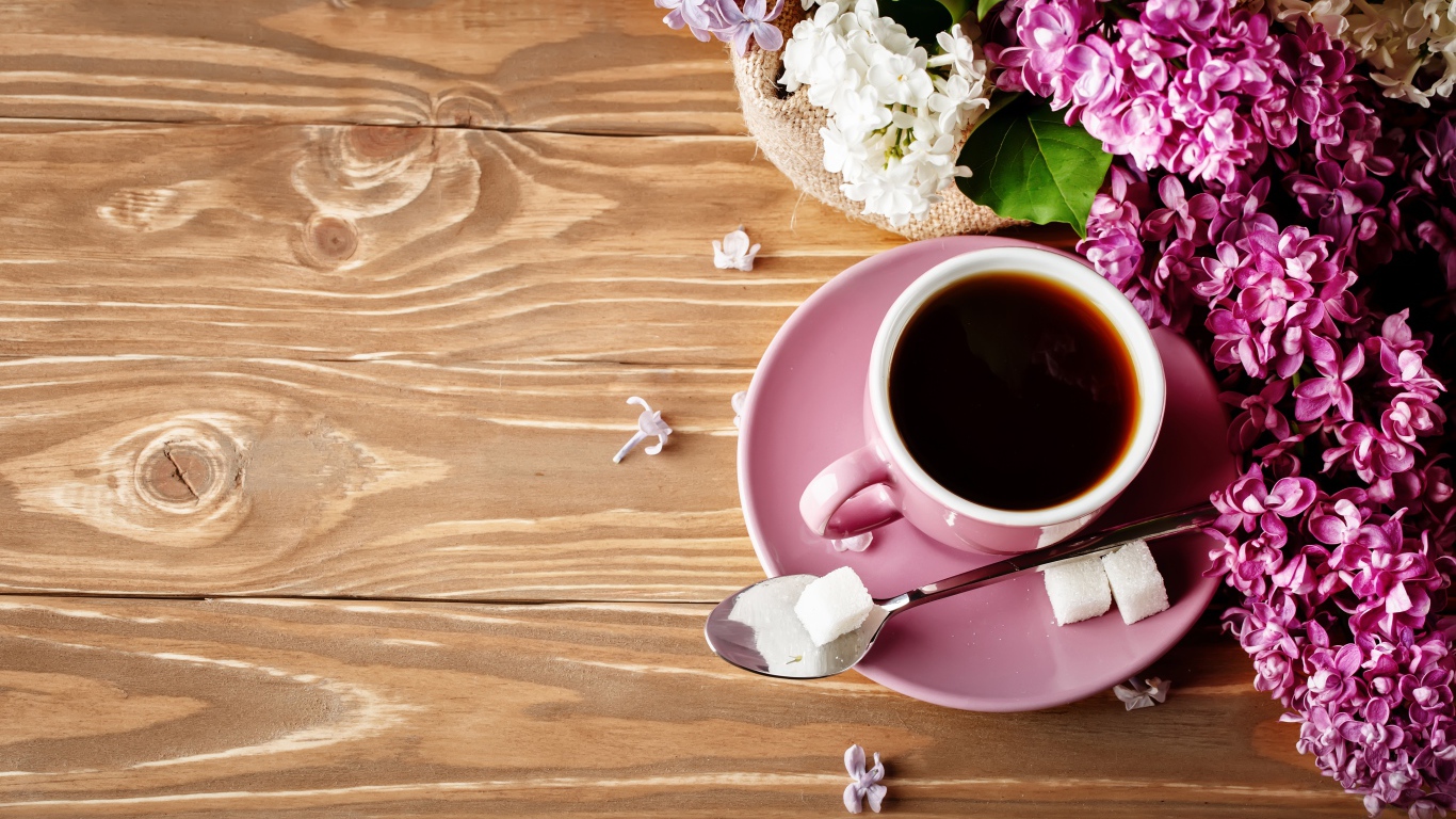 Чашка кофе на деревянном столе с сиренью 