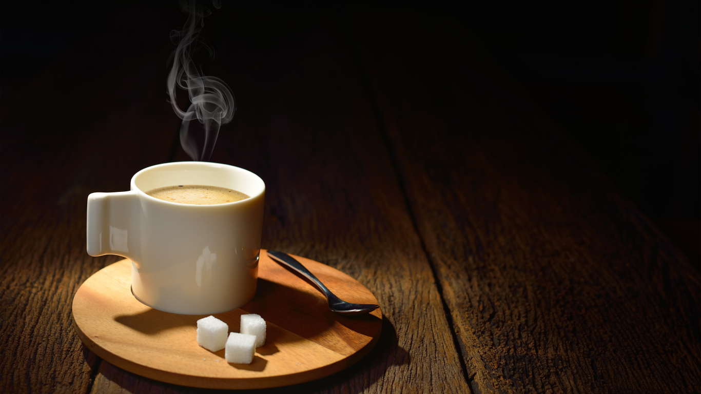 Чашка горячего кофе на столе с сахаром