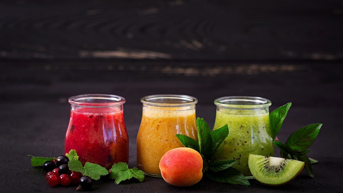 Фруктовое смузи в баночках на столе 