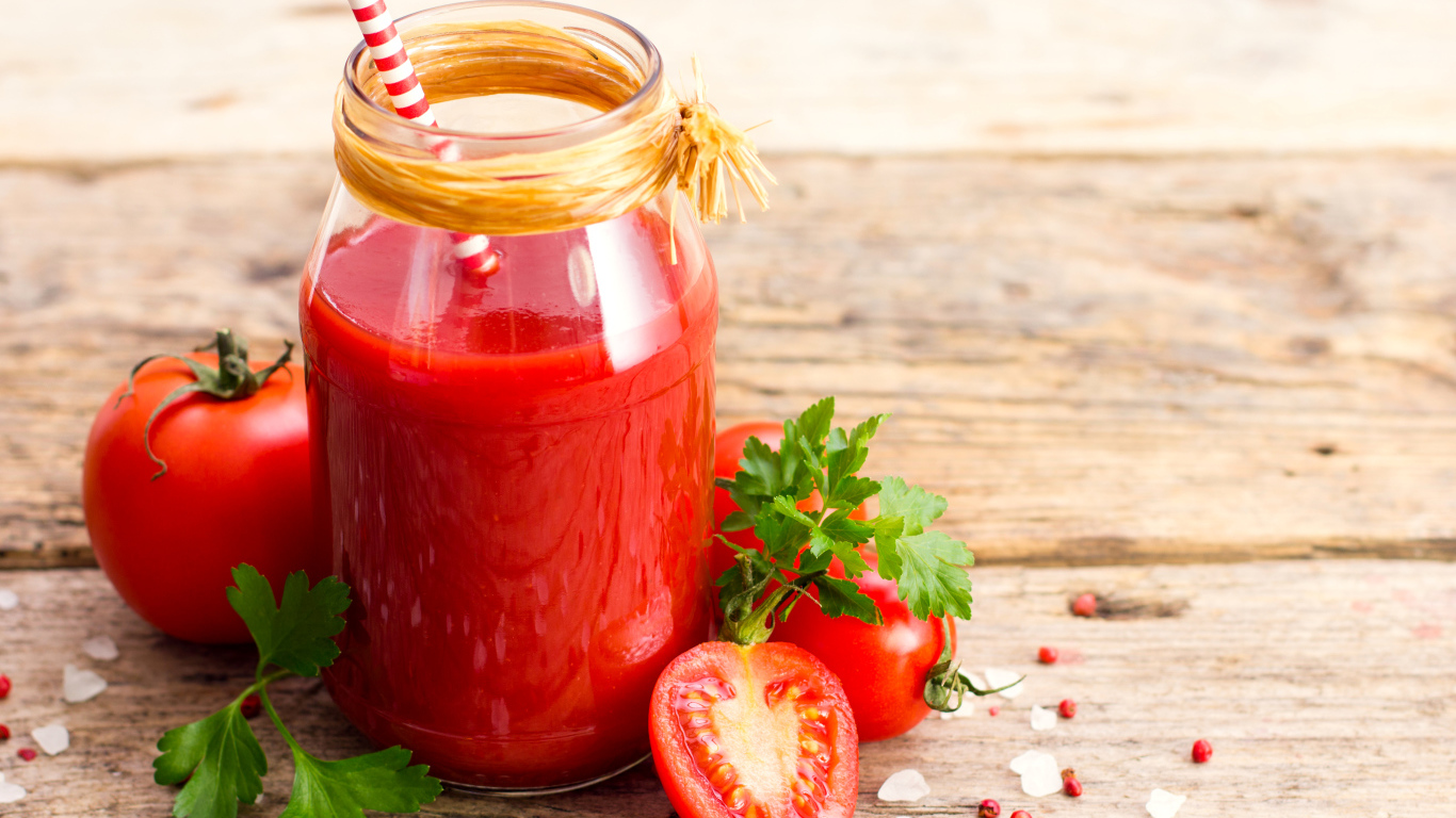 Банка томатного сока на столе с помидорами и петрушкой