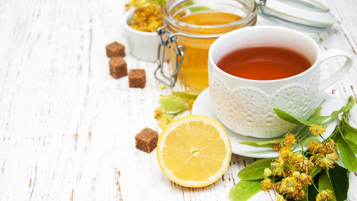 Липовый чай на столе с медом, лимоном, и сахаром