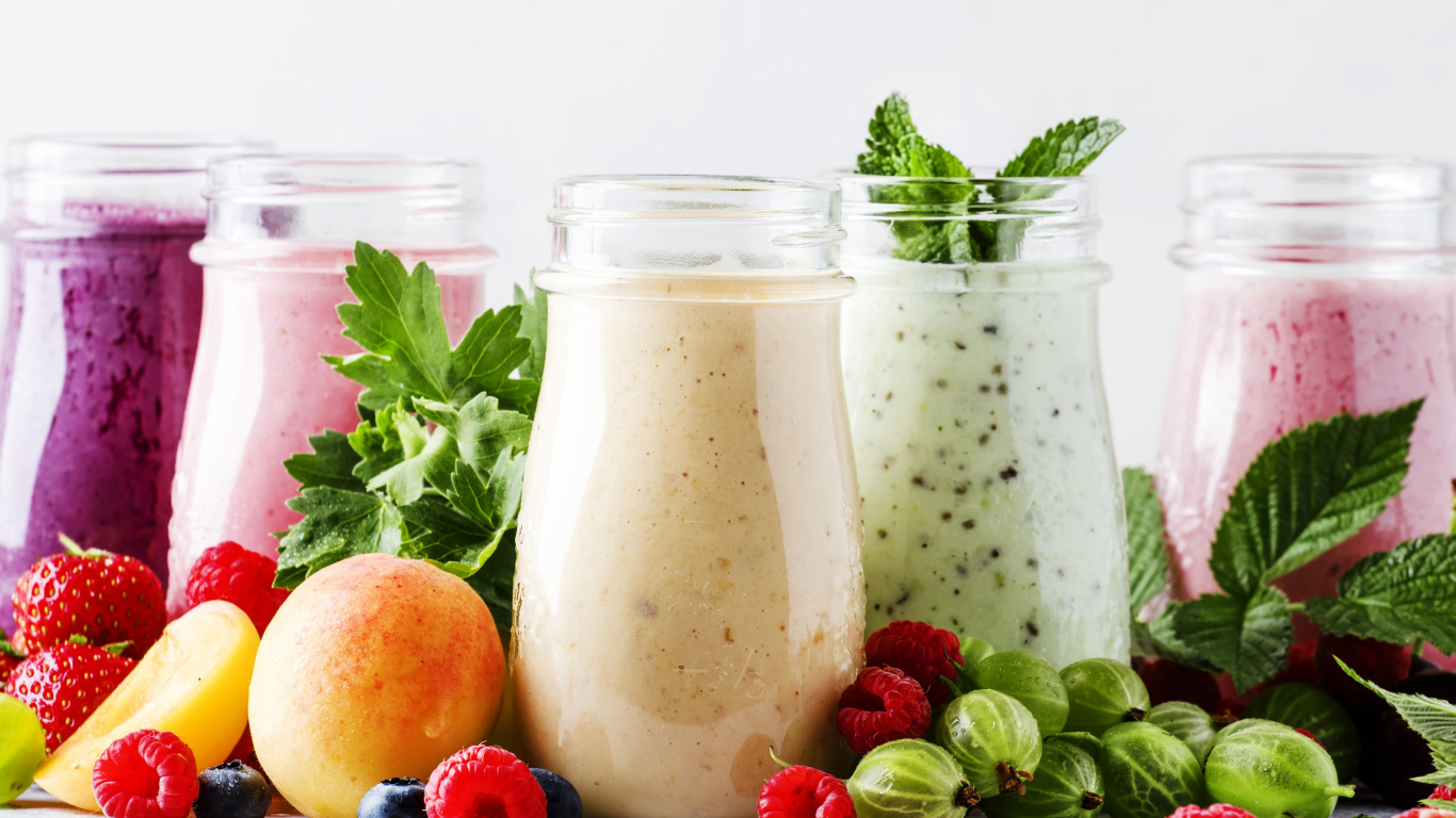 Банки со смузи на столе с ягодами 
