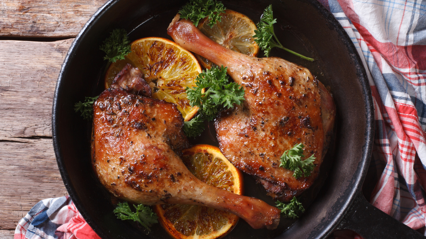 Куриные окорочка в сковороде с кольцами апельсина и петрушкой