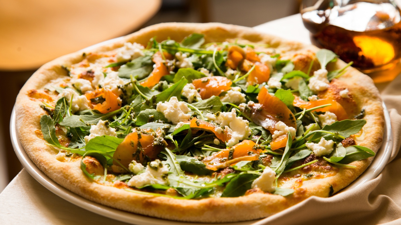 Appetizing pizza with fish and herbs on the table