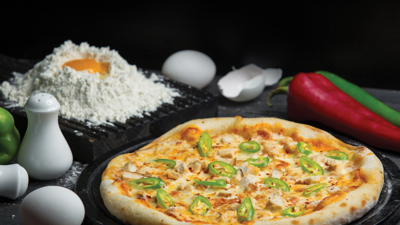 Пицца на столе с яйцами и перцем