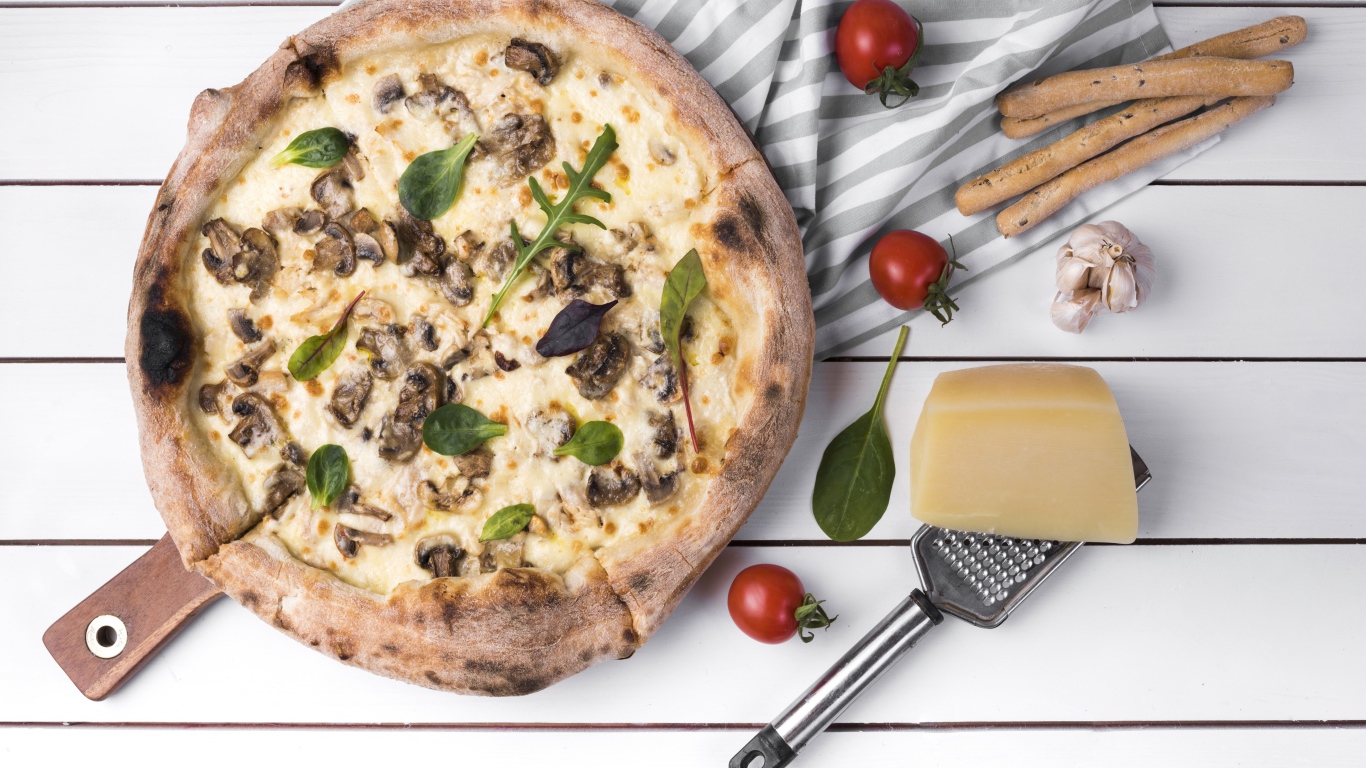 Пицца с грибами на столе с сыром и овощами