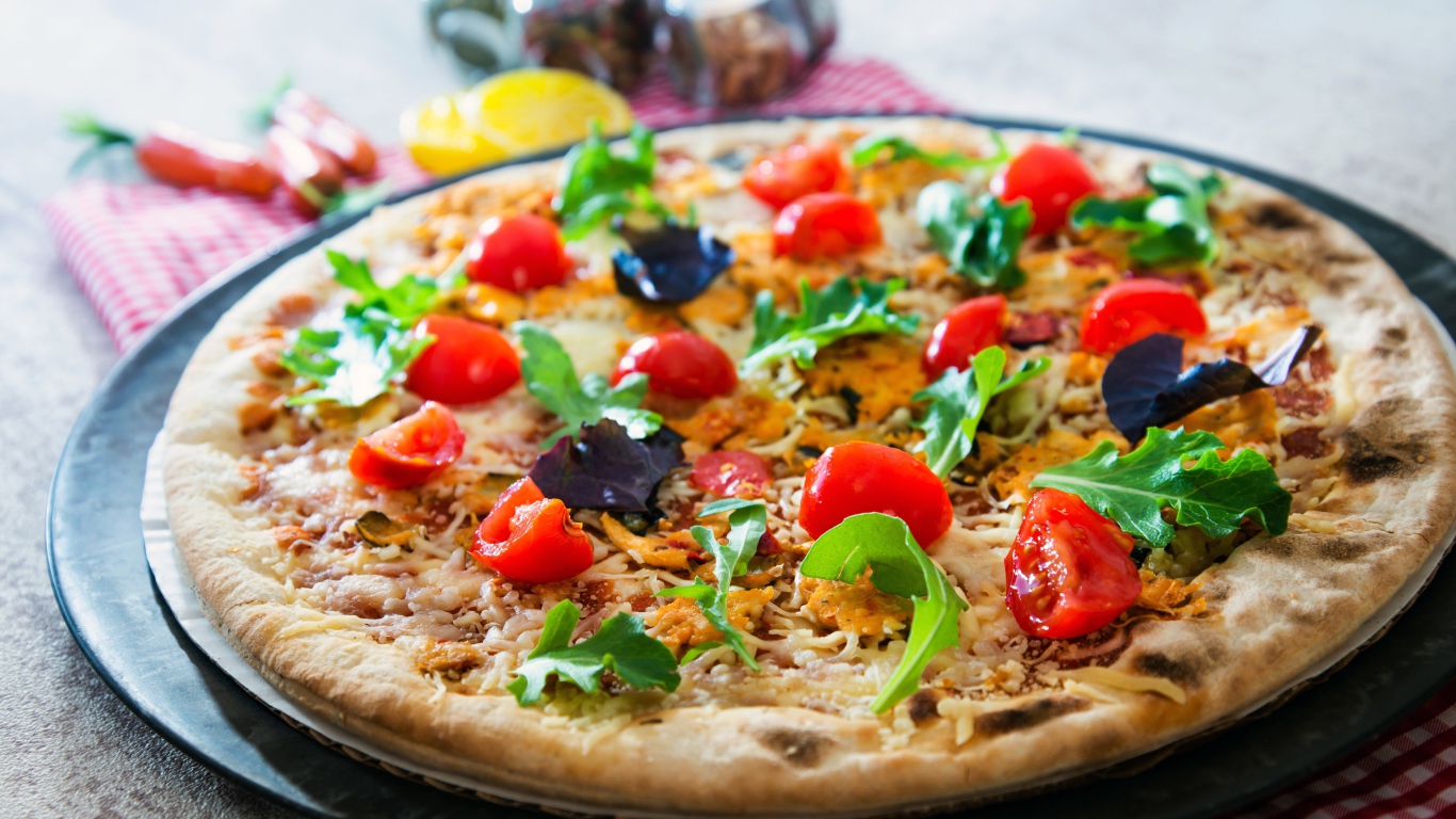 Пицца с помидорами, рукколой и сыром на столе