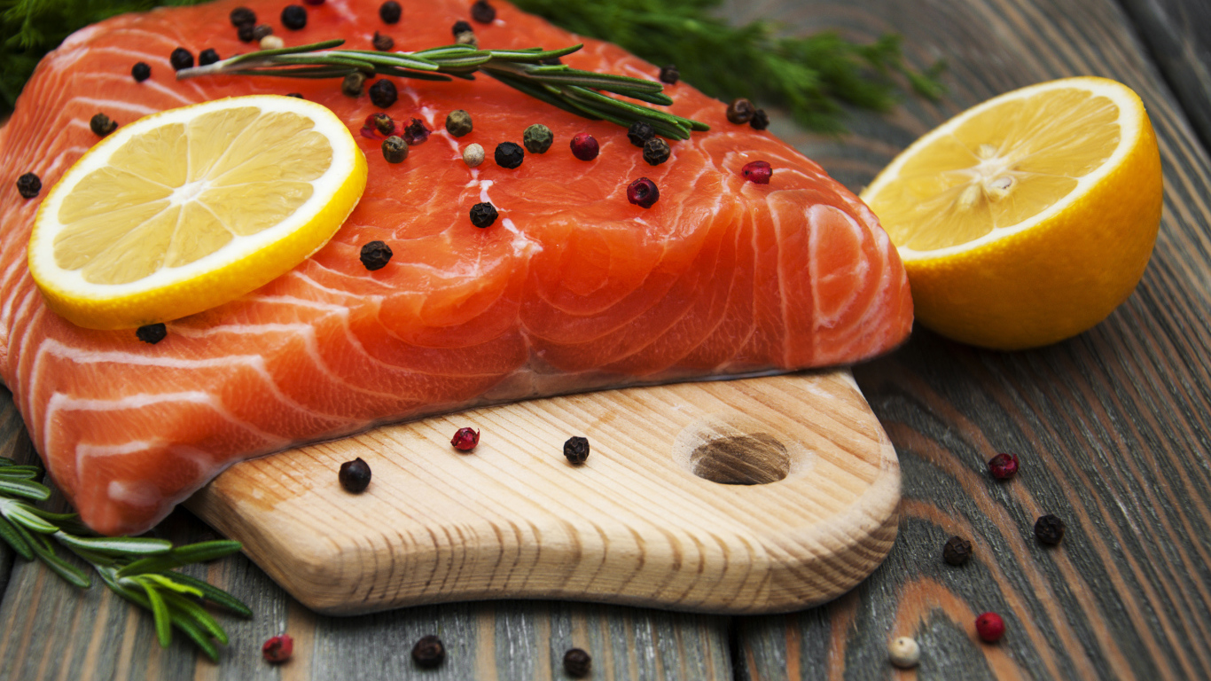 Кусок красной рыбы с лимоном и черным перцем