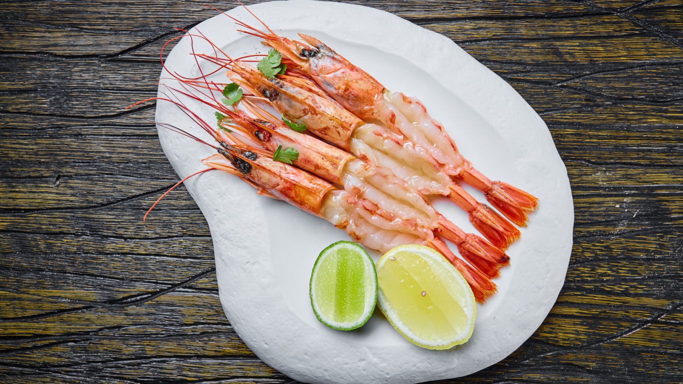 Appetizing prawns on a white plate with lemon