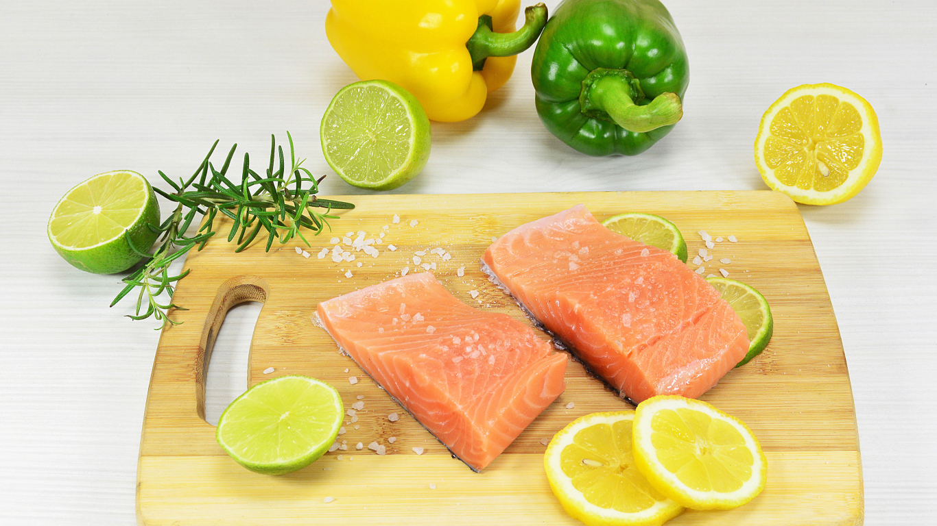 Красная рыба на разделочной доске с лимоном и перцем 